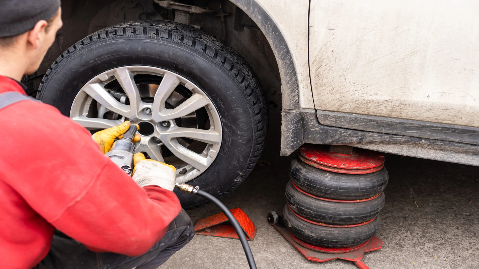 Roadside assistance technician providing flat tire change and lockout service on a Vermont highway